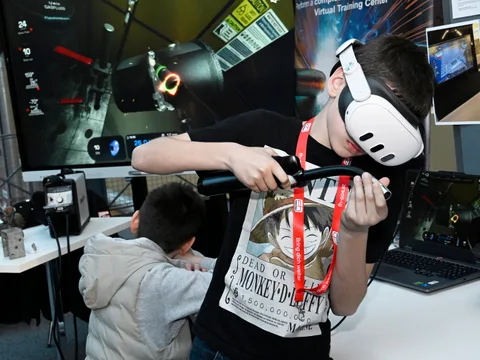 Young participant practising virtual welding with a VR headset and visible training simulation