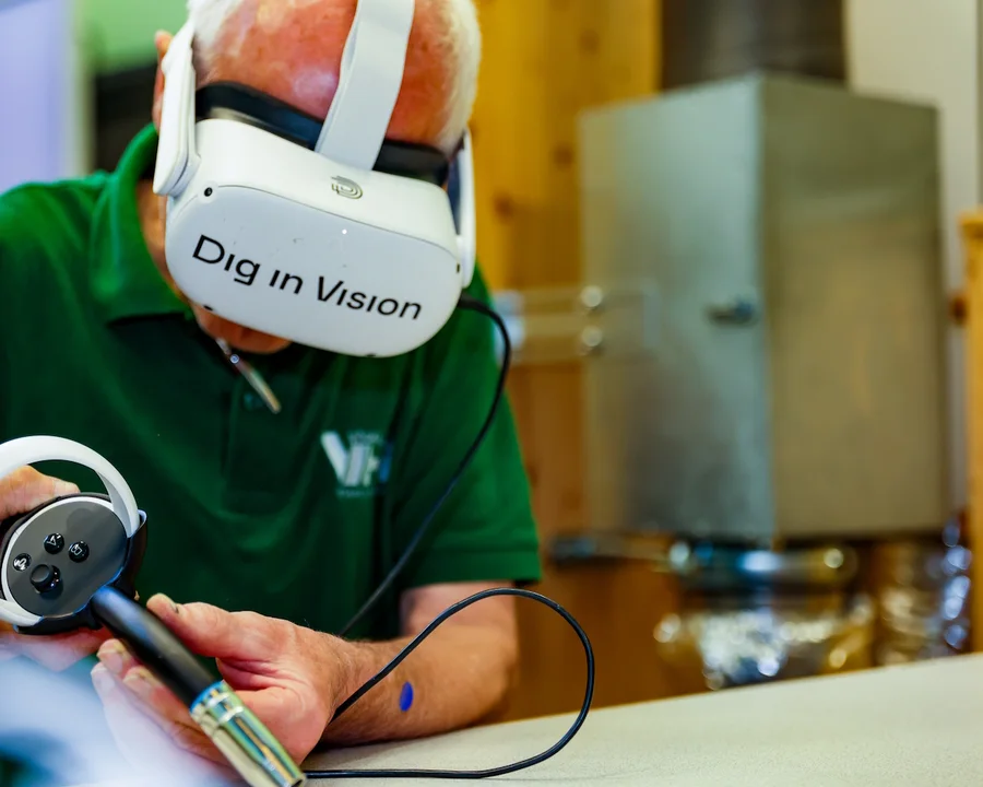 Person mit Dig in Vision XR-Headset und Controller bei der virtuellen Schweißausbildung