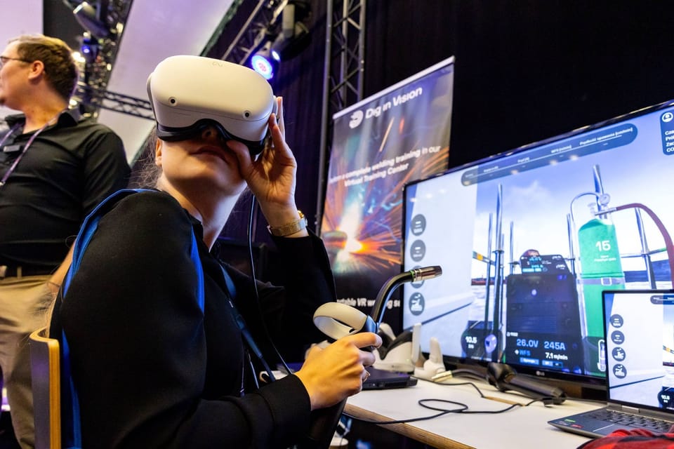 Frau mit VR-Brille an einem Messestand mit Bildschirmen